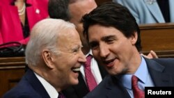 El presidente estadounidense Joe Biden y el primer ministro canadiense Justin Trudeau hablan mientras asisten a un discurso ante el Parlamento canadiense, en Ottawa, Canadá, el 24 de marzo de 2023. 