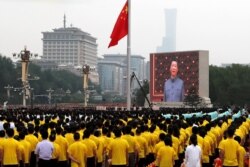 A giant screen shows Chinese President Xi Jinping singing the national anthem during a flag-raising ceremony at the event marking the 100th founding anniversary of the Communist Party of China, on Tiananmen Square in Beijing, China, July 1, 2021.