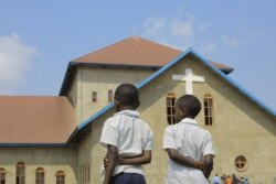 Children stand outside the Emmanuel Butsili Catholic Church in Beni, June 27, 2021, after a makeshift bomb exploded.