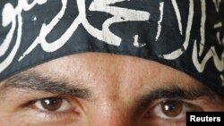 A Free Syrian Army fighter in Aleppo wears a headband reading the Islamic declaration of faith, "There is no God but God, and Mohammed is His Messenger."