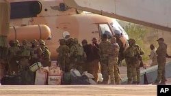 FILE - This undated photograph released in April 2022 by France's military shows Russian mercenaries boarding a helicopter in northern Mali. 