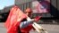 A steelworker carrying flags by German metalworkers' union IG Metall walks past a banner reading "Our future has a heart of steel" during a protest of steelworkers against European policies on April 11, 2016 in Duisburg, western Germany.