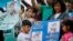 Relatives of Luis Carlos Nolasco, one of the sailors from the missing ARA San Juan submarine, gather outside the navy base in Mar del Plata, Argentina, Dec. 3, 2017, with a sign that reads in Spanish "Uncle, we wait for you, we miss you, we love you."