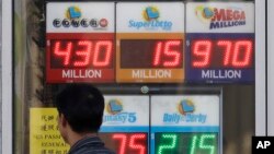 A man walks past Mega Millions and other lottery displays outside of The Lucky Spot in San Francisco, Oct. 18, 2018. The Mega Millions jackpot has climbed to $970 million, inching ever-closer to the $1 billion mark.