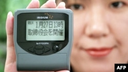 Karyawan Nippon Iridium, Nanae Saishoji, menunjukkan pager atau radio panggil buatan Iridium, 28 Desember 1998. (Foto: AFP/dok)