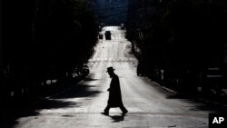 An ultra-Orthodox Jew crosses a mainly deserted street because of the government's measures to help stop the spread of the coronavirus, in Bnei Brak, Israel, April 8, 2020. 