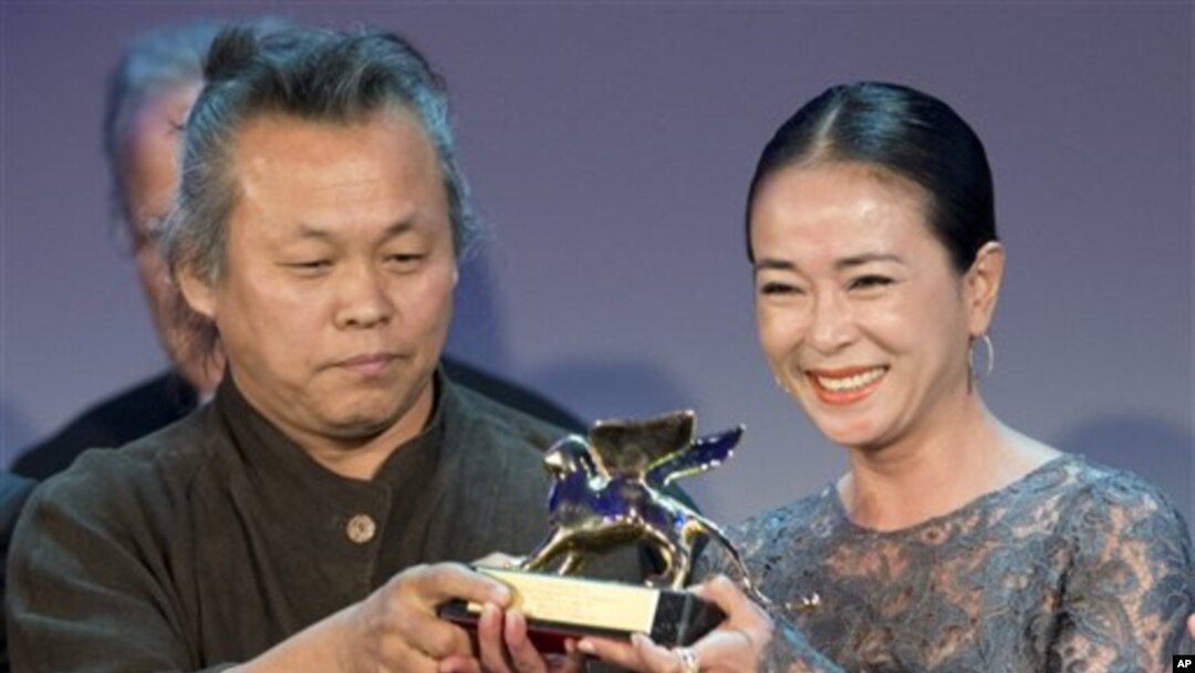 Đạo diễn Kim Ki-duk (trái) và diễn viên Cho Min-soo nhận giải thưởng Sư Tử Vàng cho phim Pieta tại Liên hoan phim Venice