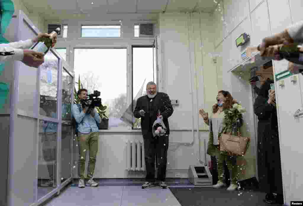 Russian investigative newspaper Novaya Gazeta&#39;s editor-in-chief Dmitry Muratov, one of 2021 Nobel Peace Prize winners, is greeted with an alcoholic drink by editorial workers, in Moscow, Russia.