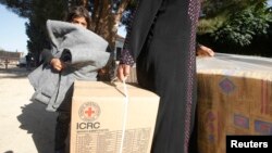 FILE - Syrian refugees in Lebanon's Bekaa Valley receive humanitarian aid from the ICRC, October 16, 2012.