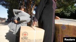 Pengungsi Suriah di desa Bekaa, Lebanon, membawa kardus berisi bantuan dari Palang Merah Internasional (ICRC). (Foto: Dok)