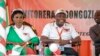 Burundi Army Gen. Evariste Ndayishimiye, center, is accompanied by his wife Angeline Ndayubaha, left, after he was chosen as the party's presidential candidate in the rural province of Gitega, Burundi Sunday, Jan. 26, 2020.