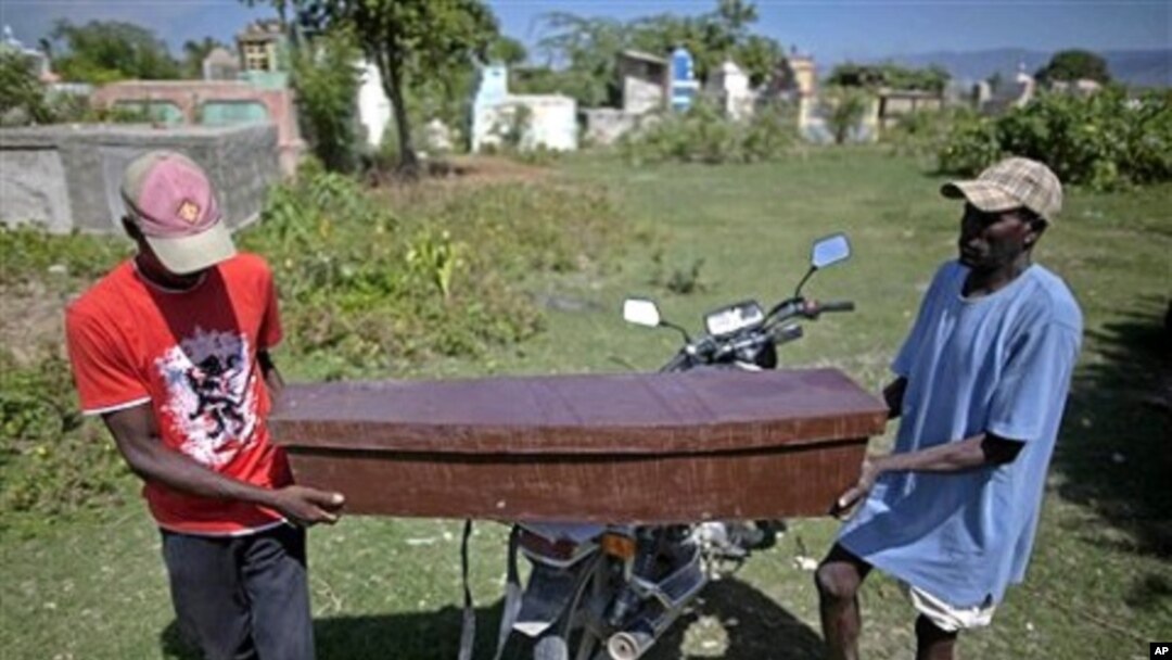 Two men carry the coffin of Frist Fleurant, 10, who died of cholera, before his burial in Rossignol, Haiti, 24 Oct. 2010.