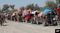 Familias afganas abandonan sus casas tras combates entre los talibanes y el ejército local en la provincia de Helmand, el 13 de octubre pasado.