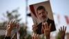 A person holds a picture of the late former Egyptian President Mohamed Morsi during a symbolic funeral ceremony, June 18, 2019 at Fatih mosque in Istanbul, Turkey.