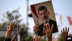 A person holds a picture of the late former Egyptian President Mohamed Morsi during a symbolic funeral ceremony, June 18, 2019 at Fatih mosque in Istanbul, Turkey.