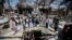 FILE- In this Oct. 13, 2016 file photo, members of the Higher Council for Civilian Community Organization inspect a destroyed funeral hall as they protest against a deadly Saudi-led airstrike on a funeral hall six days ago, in Sana'a, Yemen. 