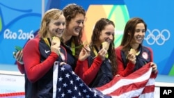 The United States team, Katie Ledecky, Allison Schmitt, Leah Smith and Maya DiRado, from left, hold up their gold medals after winning the women's 4x200-meter freestyle relay during the swimming competitions at the 2016 Summer Olympics, Thursday, Aug. 11, 2016.