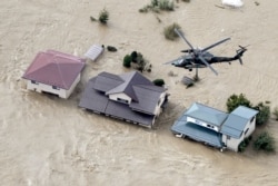 An aerial view shows a Japan Self-Defense Force helicopter flying over residential areas flooded by the Chikuma River following Typhoon Hagibis in Nagano, Japan, Oct. 13, 2019, in this photo taken by Kyodo.