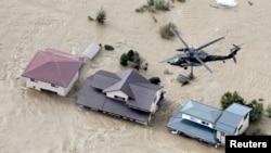 An aerial view shows a Japan Self-Defence Force helicopter flying over residential areas flooded by the Chikuma river following Typhoon Hagibis in Nagano, central Japan, October 13, 2019, in this photo taken by Kyodo.