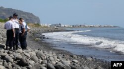 Polisi tengah memeriksa potongan reruntuhan pesawat di pantai Saint-Denis, Pulau Reunion Perancis di Samudera Hindia (2/8). 