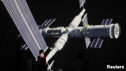 Un niño frente a una pantalla gigante que proyecta la estación espacial Tianhe de China en un museo de Beijing el 24 de abril de 2021.