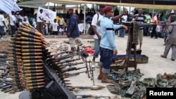 An October 2009 photo shows Nigerian militant youths displaying weapons surrendered by former militants at an arms collection center in the oil hub Port Harcourt.