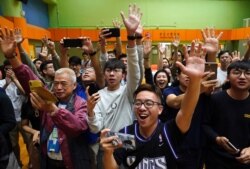 Supporters of pro-democracy candidate Angus Wong celebrate after he won in district council elections in Hong Kong, early Monday, Nov. 25, 2019.