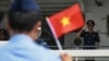 FILE - Vietnamese personnel salute flag-waving Philippine Coast Guard personnel as their Vietnam Coast Guard ship makes a port call during a goodwill visit at a port in Manila on Aug. 5, 2024.