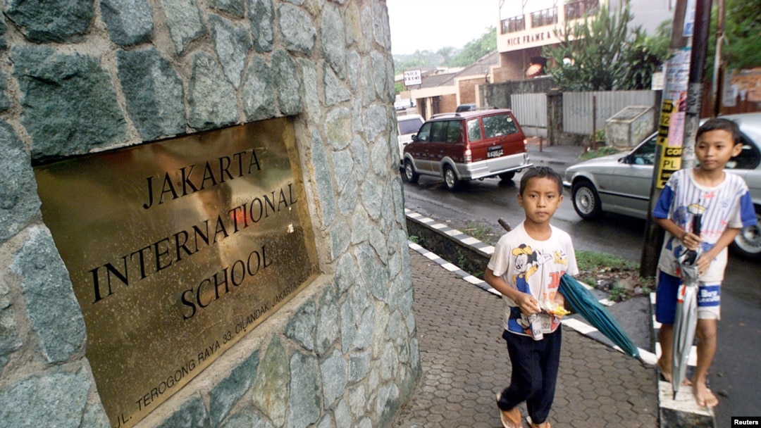 Dua anak laki-laki melewati bagian depan Jakarta International School.