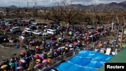 Residentes de Tacloban procuram lugar a bordo dos aviões que chegam com ajuda a cidade praticamente destruída pelo tufão Haiyan, para fugir para Manila (13 Nov. 2013)