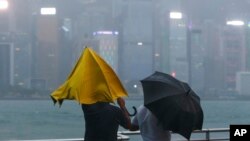 1일 홍콩 해안에 비와 강풍이 몰아치는 가운데 시민이 우산을 붙잡고 있다. 