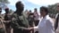 South Sudan opposition leader Riek Machar (foreground, left) shakes hands with U.N. rights chief Navi Pillay at an undisclosed location.