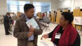 Virginia voter gets election materials from polling station worker before voting in US presidential election, Nov. 8, 2016. (Photo: D. Block / VOA) 