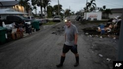 Robert Turick, 68, walks on his street as he and other neighbors work to remove debris swept onto their properties by Hurricane Milton's storm surge, in Englewood, Florida, on Oct. 11, 2024.