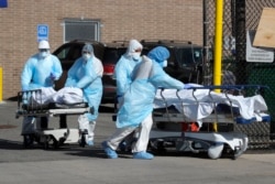 Healthcare workers wheel the bodies of deceased people outside the Wyckoff Heights Medical Center during the outbreak of the coronavirus disease (COVID-19) in the Brooklyn borough of New York City, April 6, 2020.