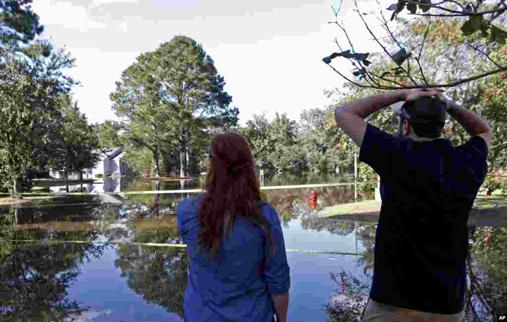  Caitlyn Cain, kushoto, na rafiki yake Sidney Daniels wakitizama hasara kutokana na mafurikoyanayotokana na kimbunga Matthew karibu na nyumbani kwake Cain, Oct. 12, 2016, huko Greenville, N.C.