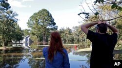 Hurricane Matthew-North Carolina: Caitlyn Cain, left, and friend Sidney Daniels inspect flooding associated with Hurricane Matthew near Cain's old home, Wednesday, Oct. 12, 2016, in Greenville, N.C. 