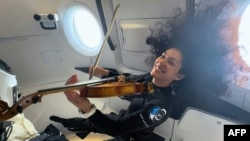 Astronaut SpaceX, Sarah Gillis, memainkan lagu "Rey's Theme" karya John Williams dengan biola dalam misi Polaris Dawn, 14 September 2024. (Foto: Polaris Program/AFP)