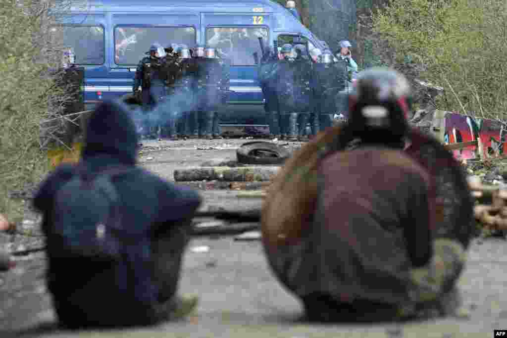 프랑스 노트르담데랑드에 있는 개발지연구역(ZAD)에서 국가헌병대원들이 불법 거주자들을 강제 퇴거시키기 위해 10년 전 지어진 캠프 철거에 착수했다. 강제 퇴거를 거부하는 시위대원들이 국가헌병대원들을 바라보고 있다.