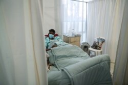 FILE - A COVID patient is being treated at a makeshift hospital run by charity organization The Gift of the Givers, in Johannesburg, South Africa, July 10, 2021.