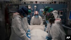 A medical team prepares to rotate a COVID-19 patient in the ICU of the Hospital del Mar, in Barcelona, Spain, Jan. 19, 2021.