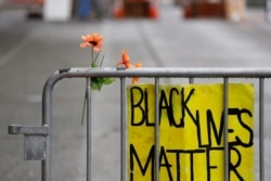A barricade stands at the end of a street where a plywood-covered and closed Seattle police precinct stands June 9, 2020, in Seattle, following protests over the death of George Floyd, a black man who was in police custody in Minneapolis.