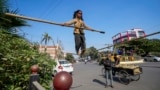 Maria, a six-year-old girl from Chhattisgarh state displays her tight rope walking skills to attract alms from people at a roadside in Prayagraj, Uttar Pradesh, India, Dec. 5, 2024.