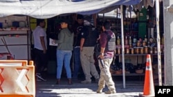 Miembros de la Unidad de Investigación Criminal del estado de Guanajuato realizan una investigación en una zona comercial en Guanajuato, México, donde ocho personas fueron asesinadas la noche del pasado sábado por un grupo de varios hombres armados el 1 de diciembre de 2024. AFP