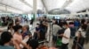 People queue up to check in as some of them are moving to the U.K. at the Hong Kong airport, June 30, 2021. 