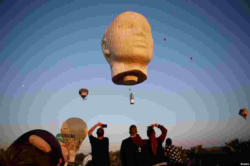 People watch hot air balloons flying overhead during a two-day international hot air balloon festival in Eshkol Park near the southern city of Netivot, Israel.