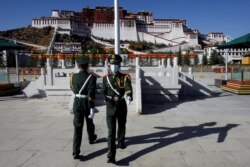 Paramilitary police officers swap positions during a change of guard in front of Potala Palace in Lhasa, during a government-organized tour of the Tibet Autonomous Region on October 15, 2020. Thomas Peter/Reuters