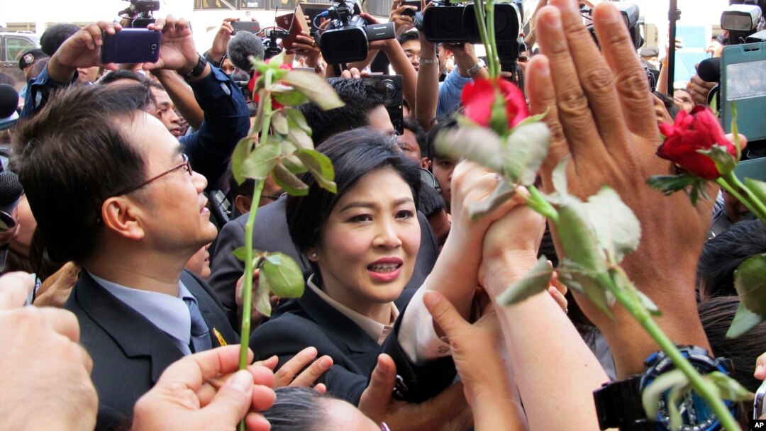 Mantan PM Thailand Yingluck Shinawatra (tengah) berjalan melewati para pendukungnya saat meninggalkan Mahkamah Agung Thailand di Bangkok (19/5).