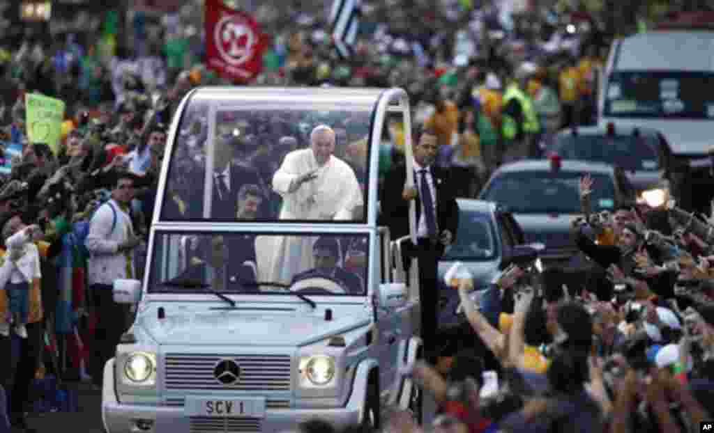Pope Francis waves in his way to the Stations of the Cross in Rio de Janeiro, Brazil, Friday, July 26, 2013. Also known as the Way of the Cross, Via Crucis and Via Dolorosa, the Stations of the Cross are built around reflections on Jesus' last steps leadi