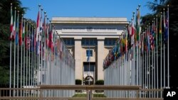 Flagpoles line in rows in front of a building of the United Nations in Geneva, Switzerland Monday, June 14, 2021. The lakeside city known as a Cold War crossroads and a hub for Swiss discretion, neutrality and humanitarianism, is set to return to a…